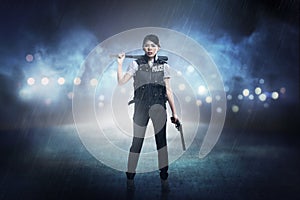 Pretty woman in police vest holding baseball bat