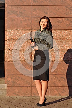 Pretty woman portrait near wall with notebook