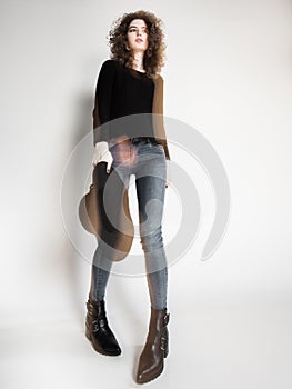 Pretty woman posing in denim pants and boots and black hat - intentional motion blur