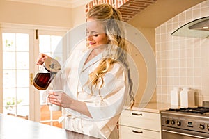 Pretty woman pouring coffee in a mug