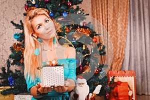 Pretty woman with present and Christmas tree