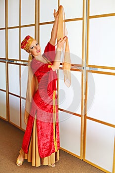 Pretty woman in red Andalusian costume poses with