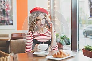 Pretty woman in red beret with smartphone