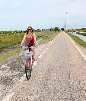 Pretty woman on the red bike in summer