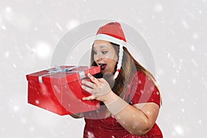 Pretty woman with a red hat opening a gift box - Christmas concept