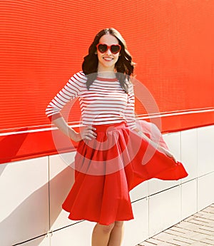 Pretty woman in red sunglasses and dress against the colorful