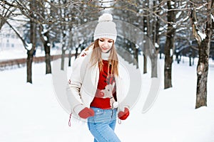 Pretty woman in a red sweater, a white cap and a jacket, knitted