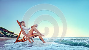 Pretty woman relaxing on a lounger beach and drinks soda water. summer vacation concept