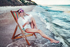 Pretty woman relaxing on a lounger beach and drinks soda water. summer vacation concept