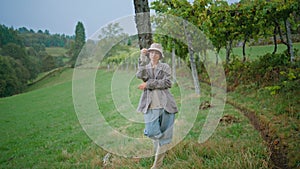 Pretty woman relaxing vine field rainy autumn day. Carefree girl holding grape