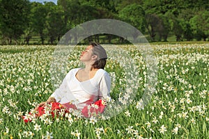 Pretty woman relaxing in white flowers field