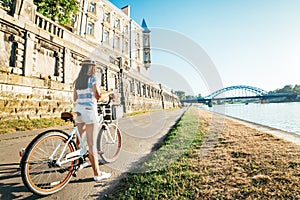 Pretty woman ride bicycle on embankment of Wisla river