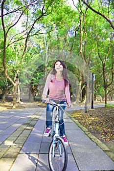 Pretty Woman riding a bike on the forest trail