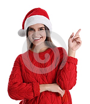 Pretty woman in Santa hat and red sweater pointing on white background
