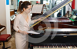 Pretty woman seller in piano music store