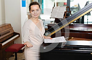 Pretty woman seller in piano music store