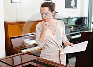 Pretty woman seller in piano music store