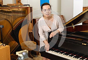 Pretty woman seller in piano music store