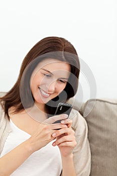 Pretty woman sending a sms with her mobile phone