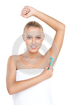 Pretty woman shaving armpit with razor.