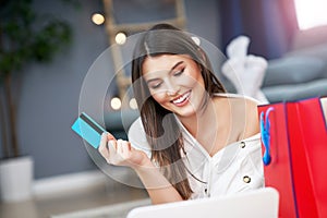 Pretty woman shopping online with credit card at home