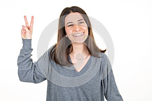 Pretty woman showing v two fingers positive and peace gesture hand on white background