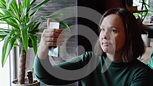 Pretty woman sitting in cafe and talking. Green dress with long sleeves