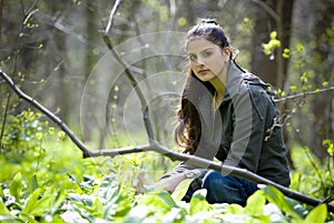 Pretty woman sitting in forest