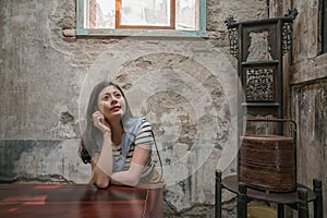 Pretty woman sitting in the old traditional house.