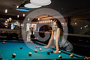 Pretty woman spend free time playing billiard snooker at pub