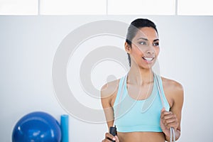 Pretty woman in sportswear holding a rope