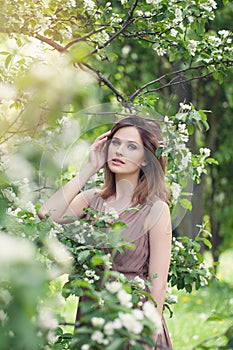 Pretty woman in spring. Beautiful girl on floral nature background, lifestyle portrait