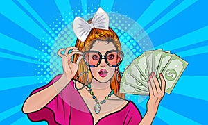 Pretty woman surprised in glasses holding money looking somthing