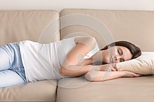 Pretty woman takes short nap during day on sofa photo