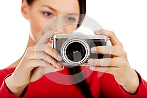 Pretty woman taking a photo using classic slr camera