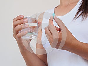 Pretty woman taking pill on white background. Healthcare and med