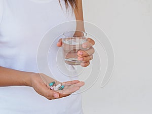 Pretty woman taking pill on white background. Healthcare and med