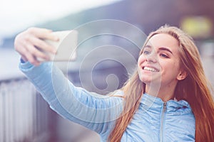Pretty woman taking a selfie. Beautiful girl walking on the streets and photographing some landmarks. Blonde taken