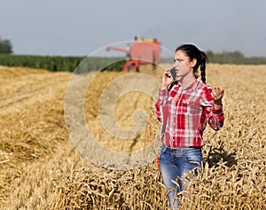 Pretty woman talking on mobile phone in wheat field
