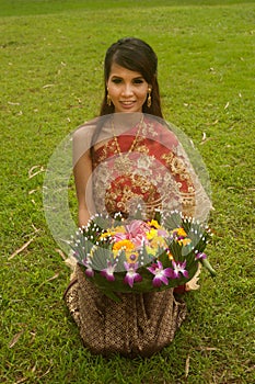 Pretty woman in Thai style clothes in posing hold flower joist.