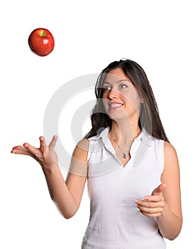 Pretty woman tosses apple in air isolated