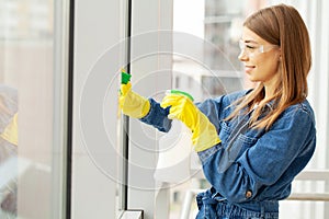 Pretty woman in uniform with supplies cleaning in office