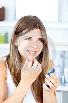 Pretty woman using vaseline for her lips