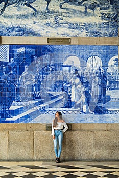 Pretty woman waiting at train station in Porto for travel in summer. Travel concept.