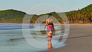 Pretty Woman Walking On The Beach At Sunset.