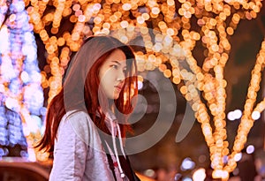 Pretty woman is walking in street of Sendai Japan with christmas light decoration in the background for winer holidays