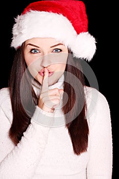 Pretty woman wearing santa hat saying shh photo