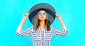 Pretty woman wearing straw hat posing in the city