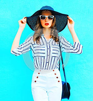 Pretty woman wearing straw hat, white pants