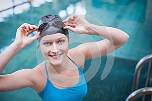 Pretty woman wearing swim cap and swimming goggles